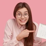 Lady grinning pointing at calendar