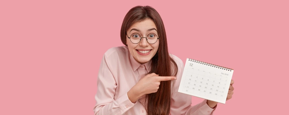 Lady grinning pointing at calendar