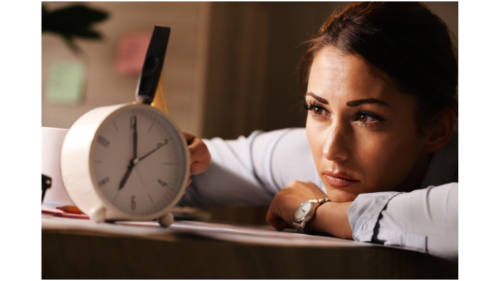 Woman staring intently at clock