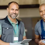 2 mechanics smiling at camera