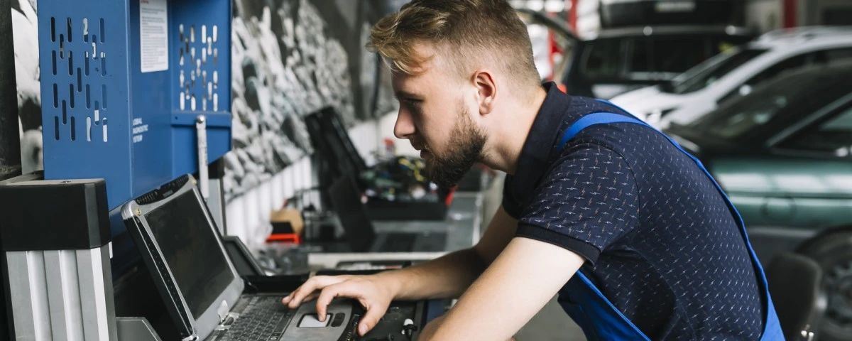 Mechanic using laptop in workshop