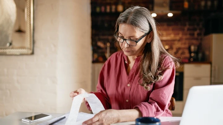 Lady inspecting a receipt at her desk