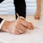 Groom signing marriage certificate