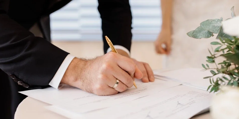 Groom signing marriage certificate