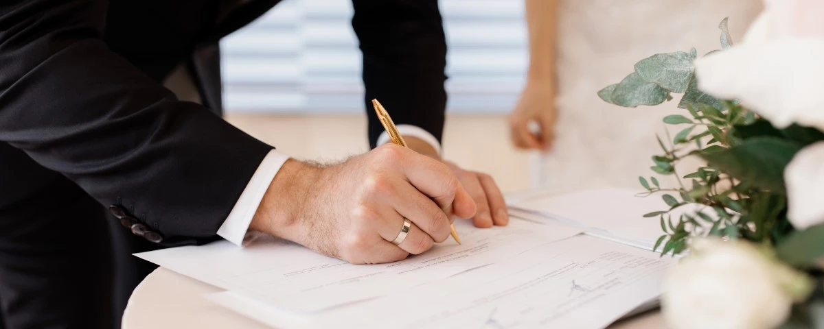 Groom signing marriage certificate