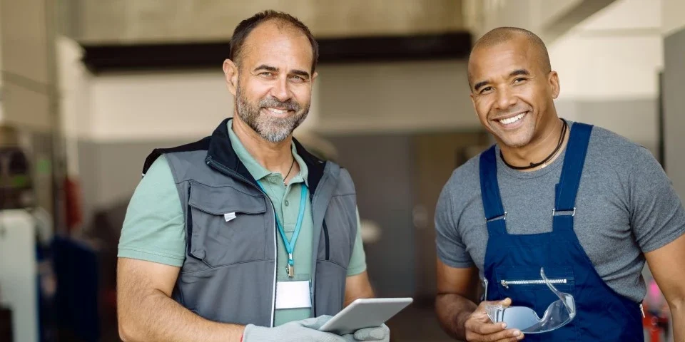 2 mechanics smiling at camera