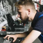 Mechanic using laptop in workshop