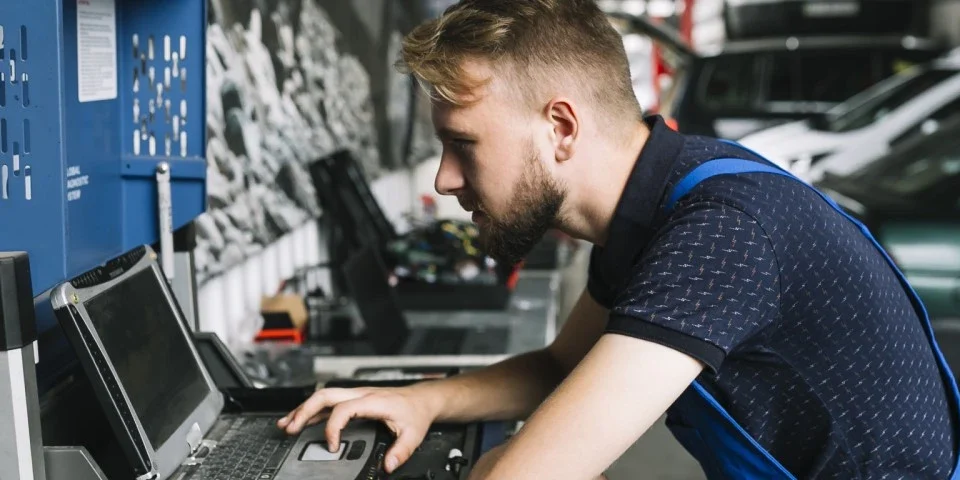 Mechanic using laptop in workshop