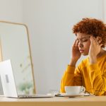 Woman looking at her laptop stressed.