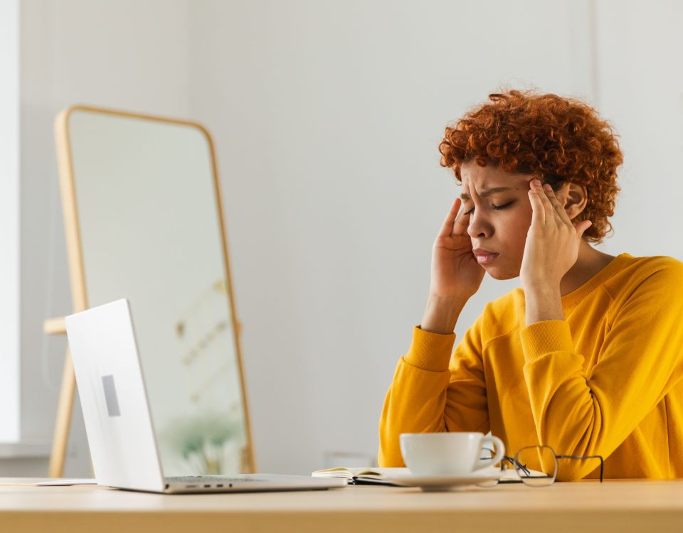 Woman looking at her laptop stressed.