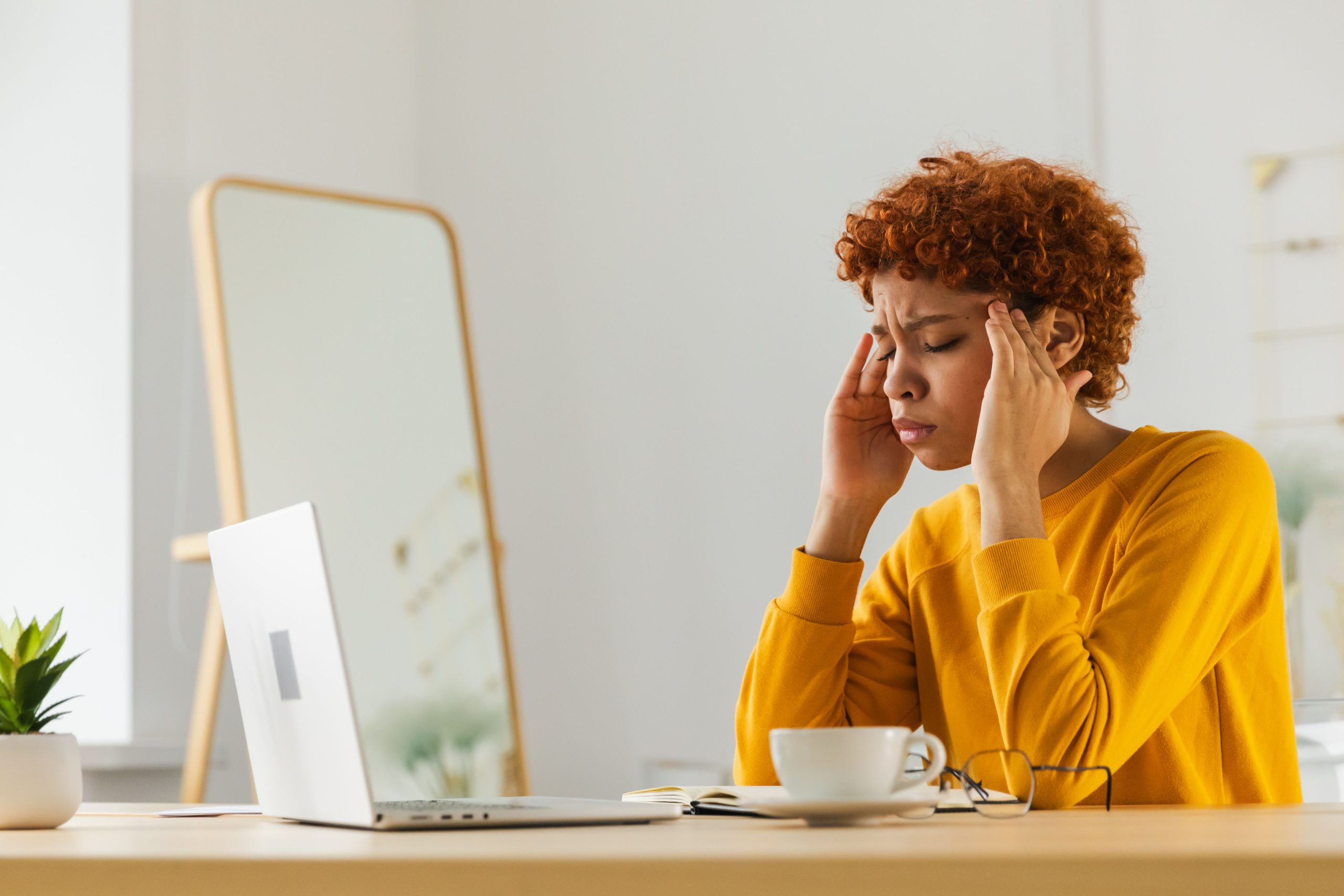 Woman looking at her laptop stressed.